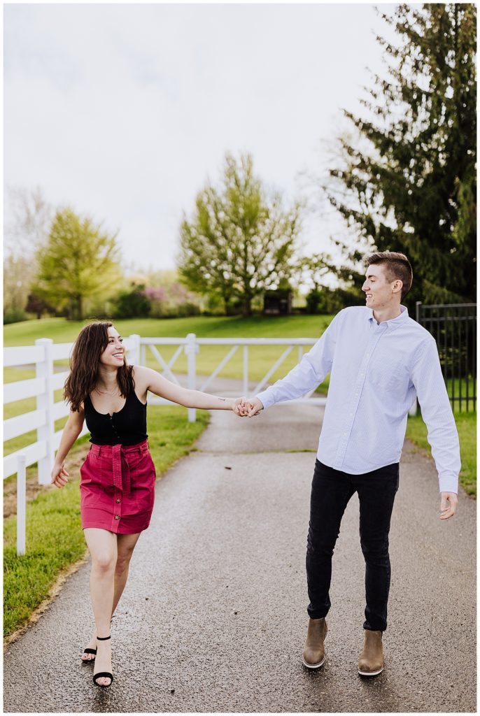couple pose walking together down a path