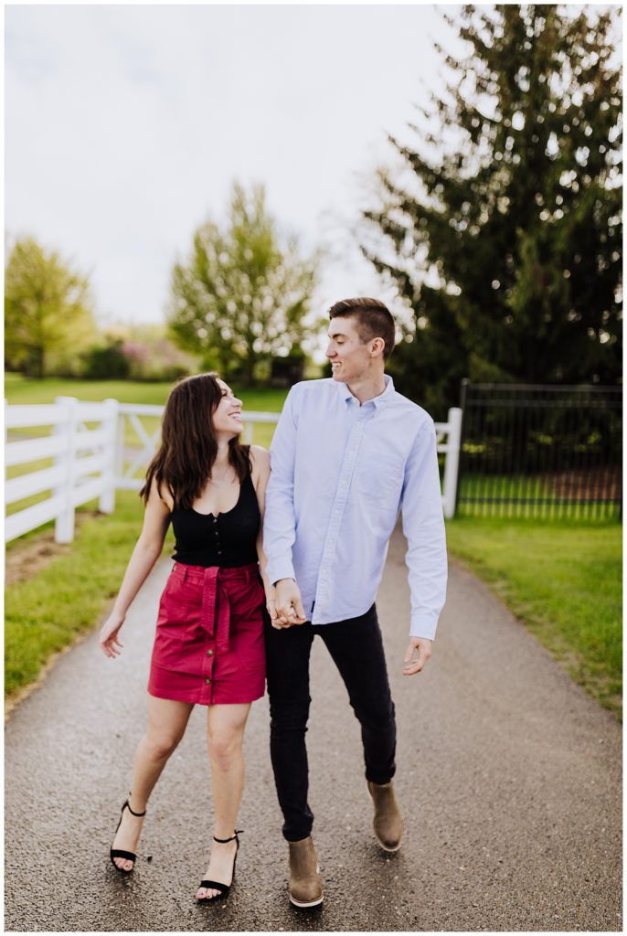 couple pose walking together down a path