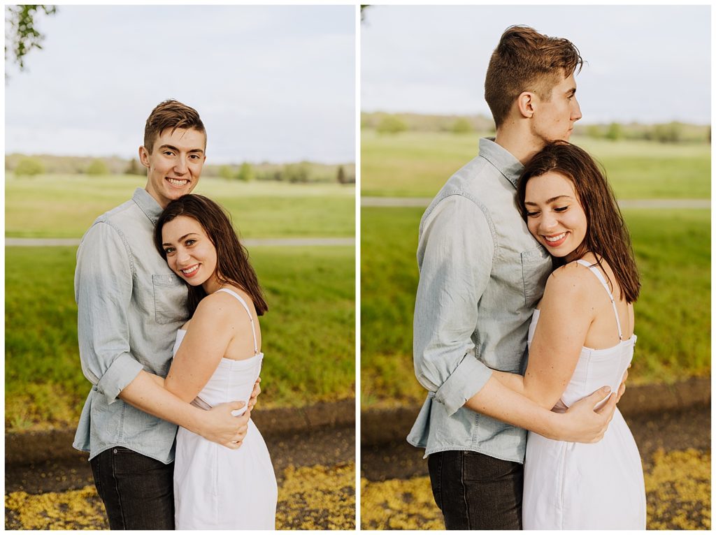 couple pose hugging and looking at camera