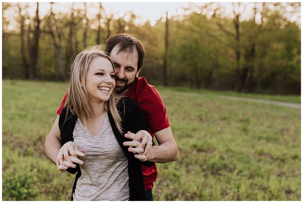 couple pose laughing and holding hands