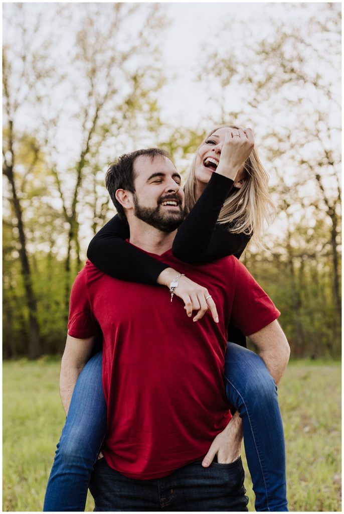 couple pose on his back laughing 
