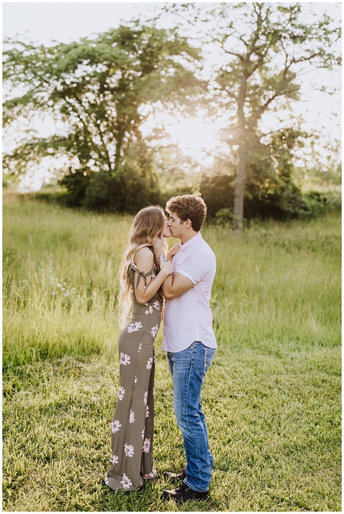 couple kissing in field of grass