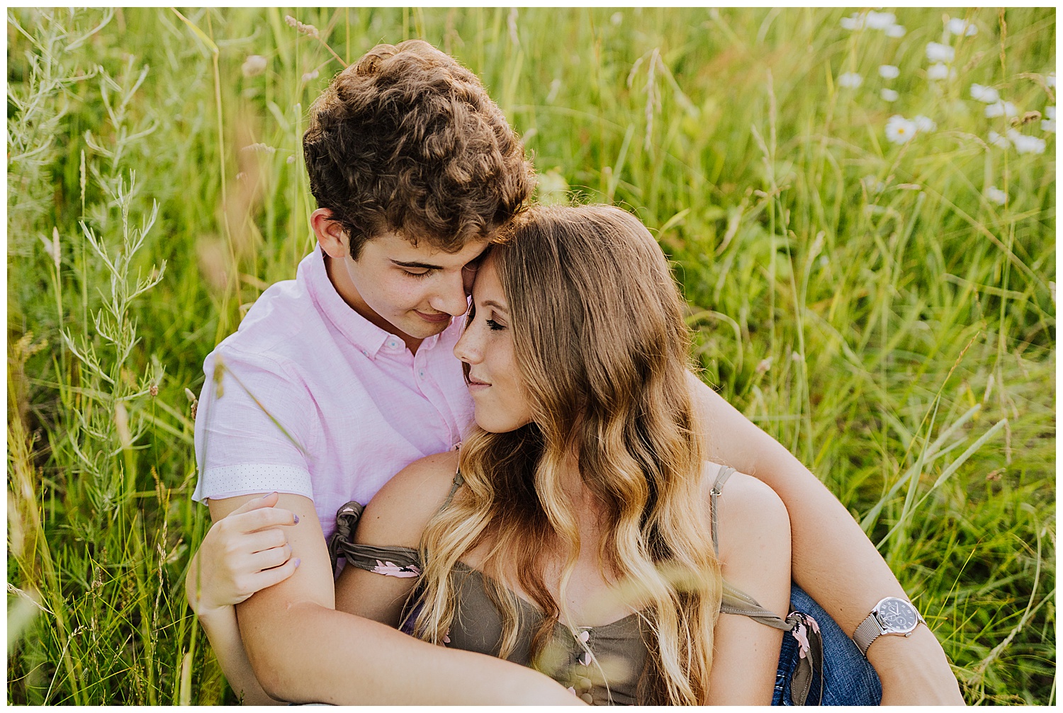couple sitting in field of grass