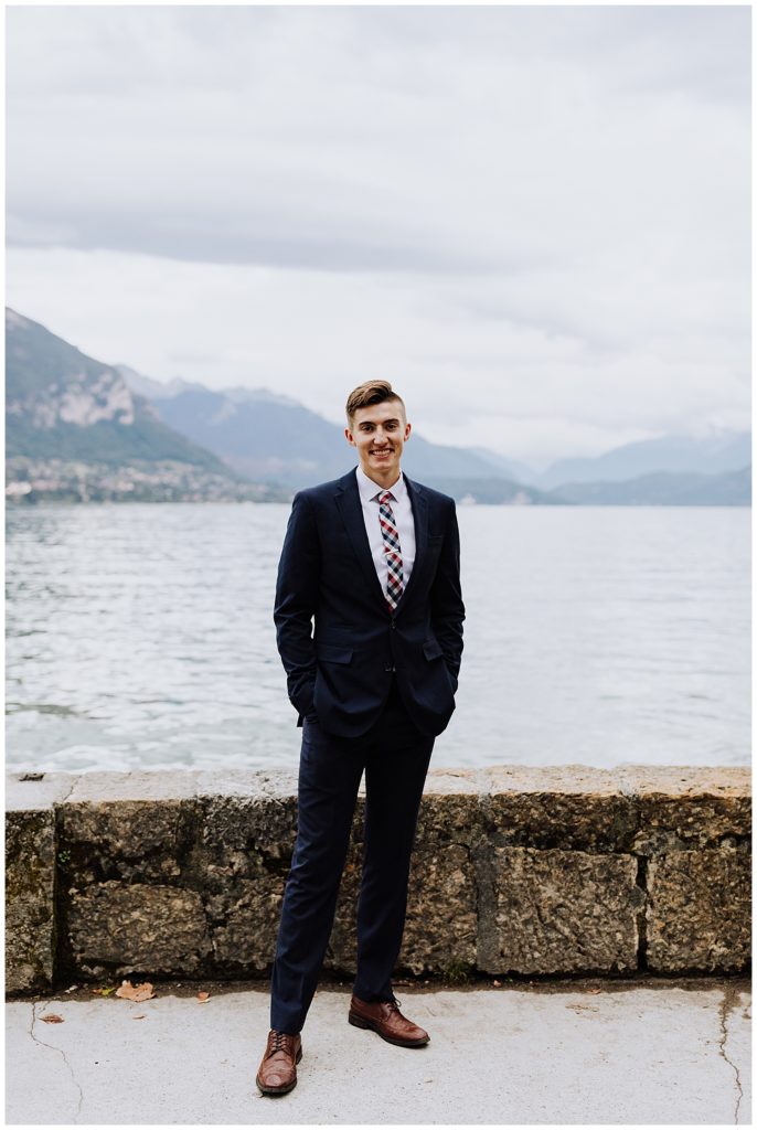 groom in front of mountains and lake in annecy france