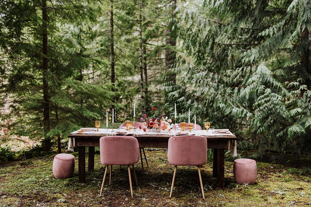 wedding reception table in woods, pink chairs