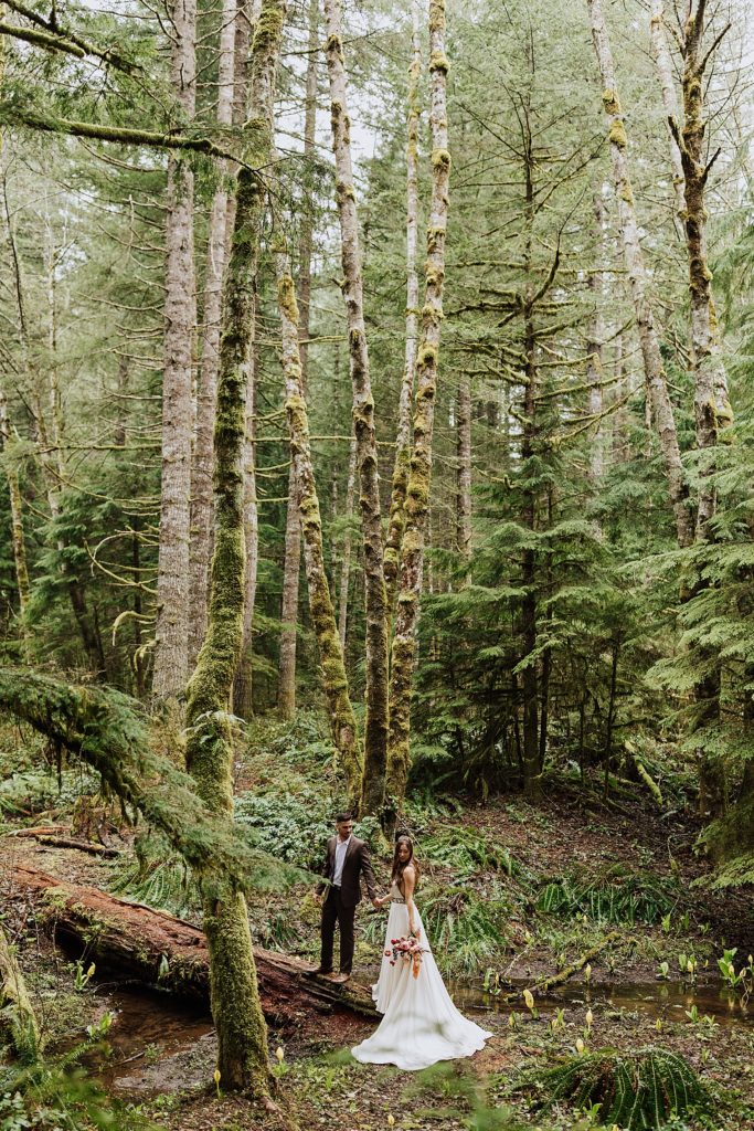 bride and groom walking in woods