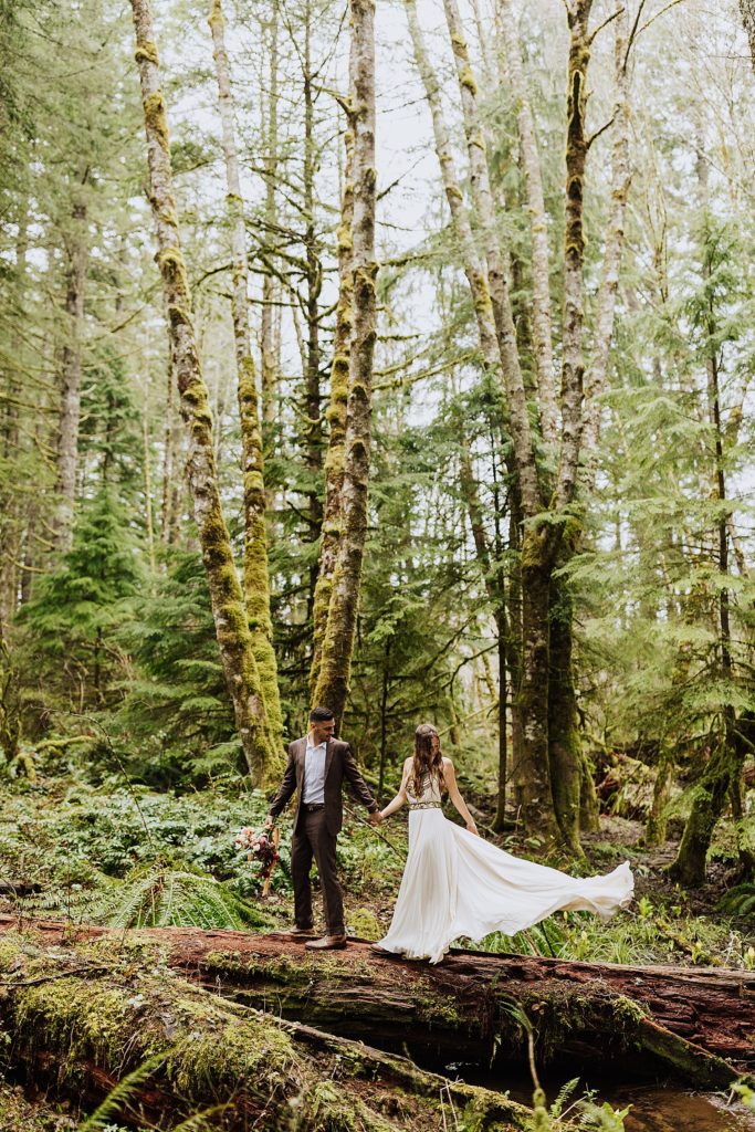 bride fluffing her dress in woods