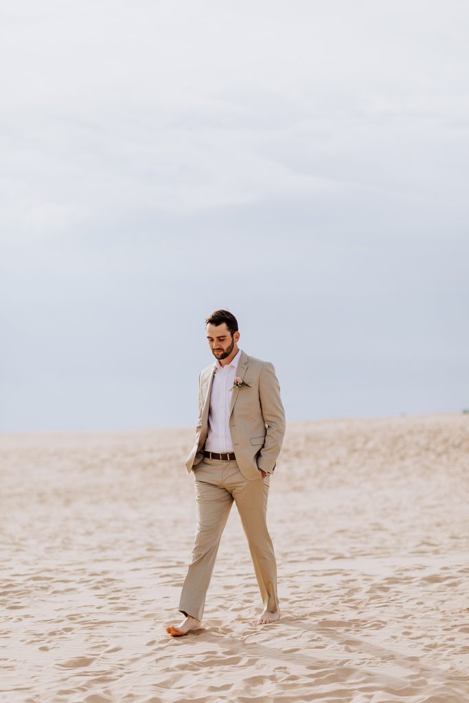 groom walking down the aisle on beach