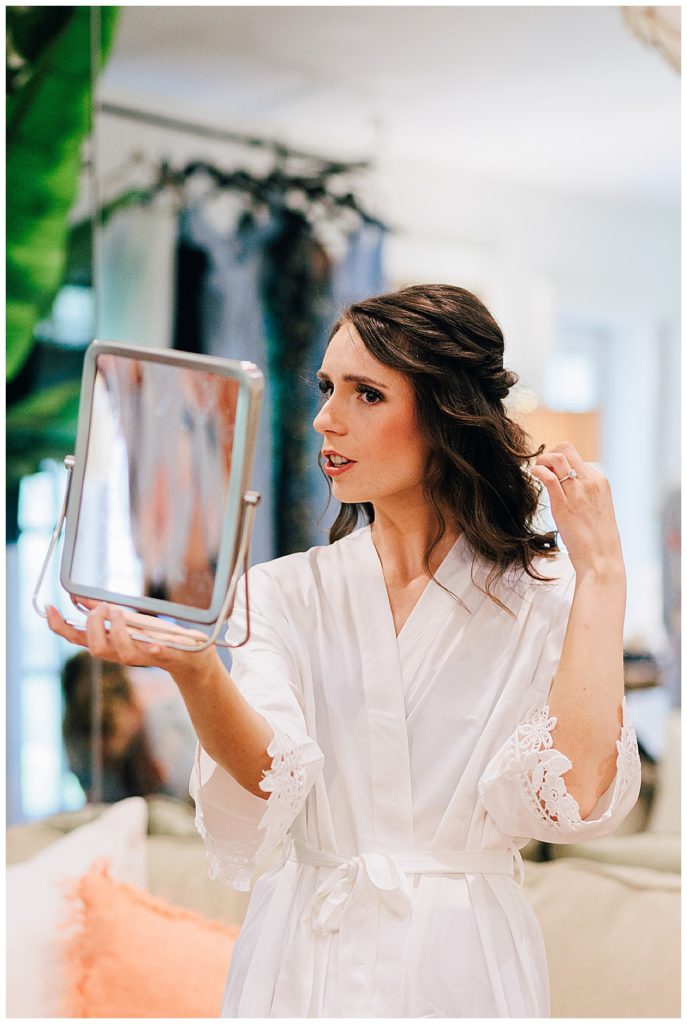 Bride looking at mirror by Detroit Wedding Photographer