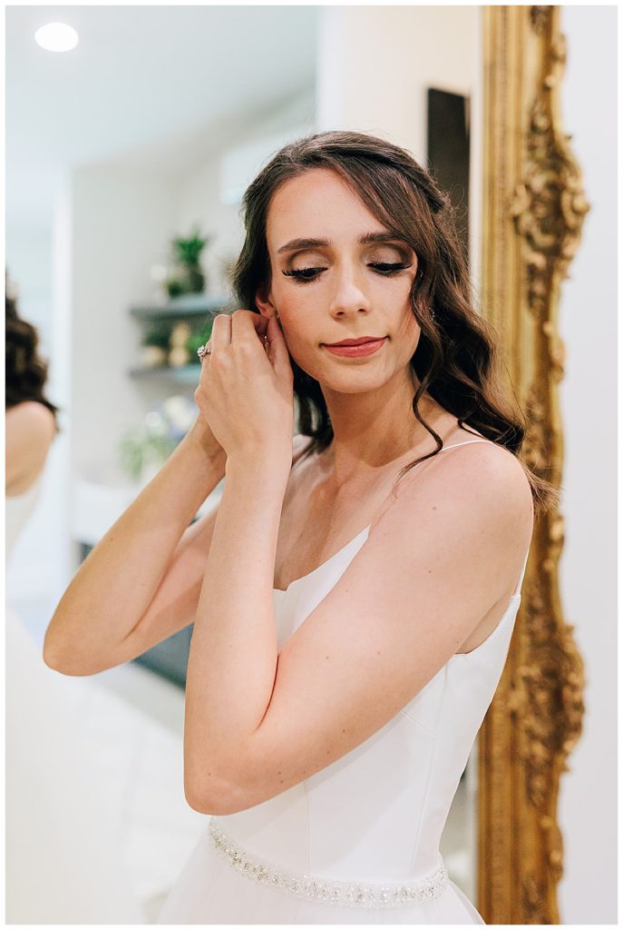 Bride adjusts wedding earrings by Detroit Wedding Photographer