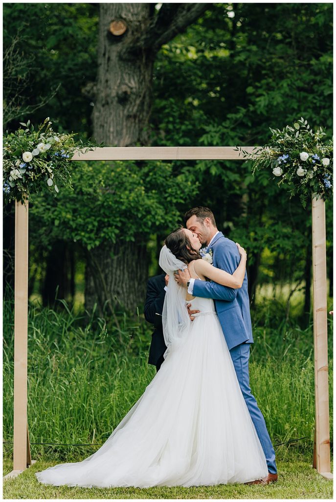 Bride and groom share first kiss by Detroit Wedding Photographer