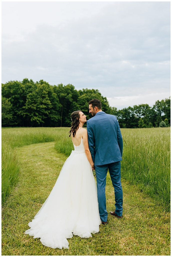 Husband and wife in green field by Detroit Wedding Photographer