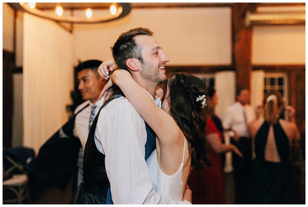 On the dance floor the newly married couple share a hug by Detroit Wedding Photographer