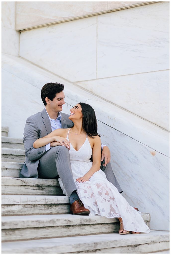 Man and woman smile at each other on stairs for Kayla Bouren Photography