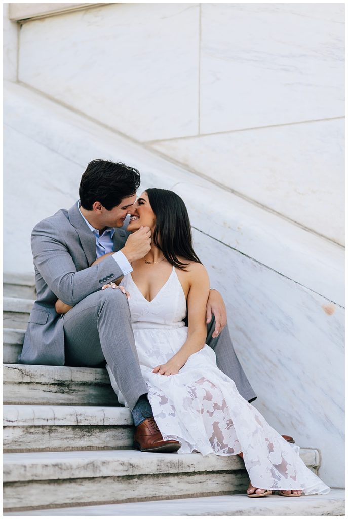 Couple share a kiss on stairs during Detroit Institute of the Arts Engagement Session