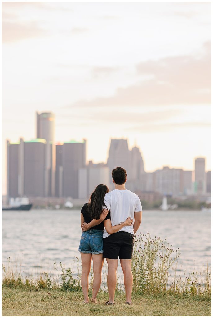 Couple embraces on lake front during Detroit Institute of the Arts Engagement Session