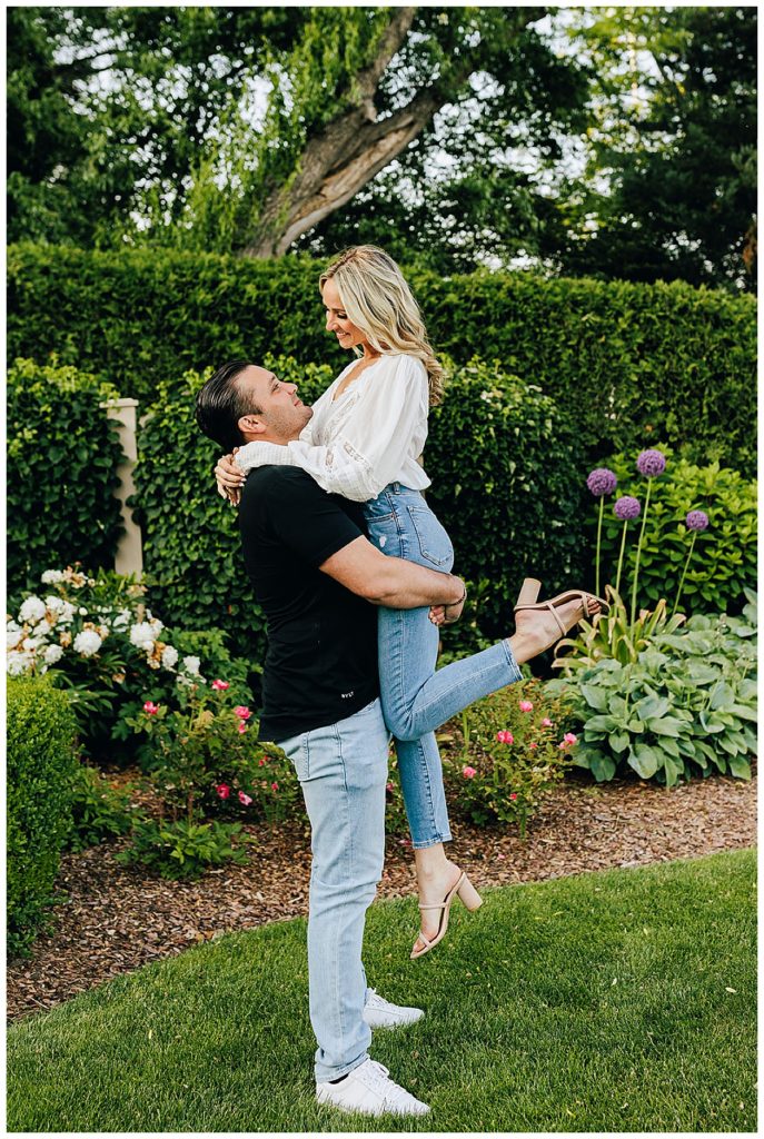 Man picks up smiling woman during Grosse Pointe Engagement Session