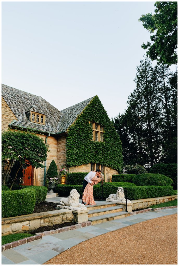 Couple share a dip and kiss in front of estate by Kayla Bouren Photography.