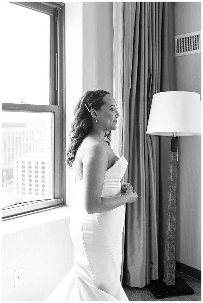 Bride staring distance after getting ready for for elegant Yacht Club wedding.