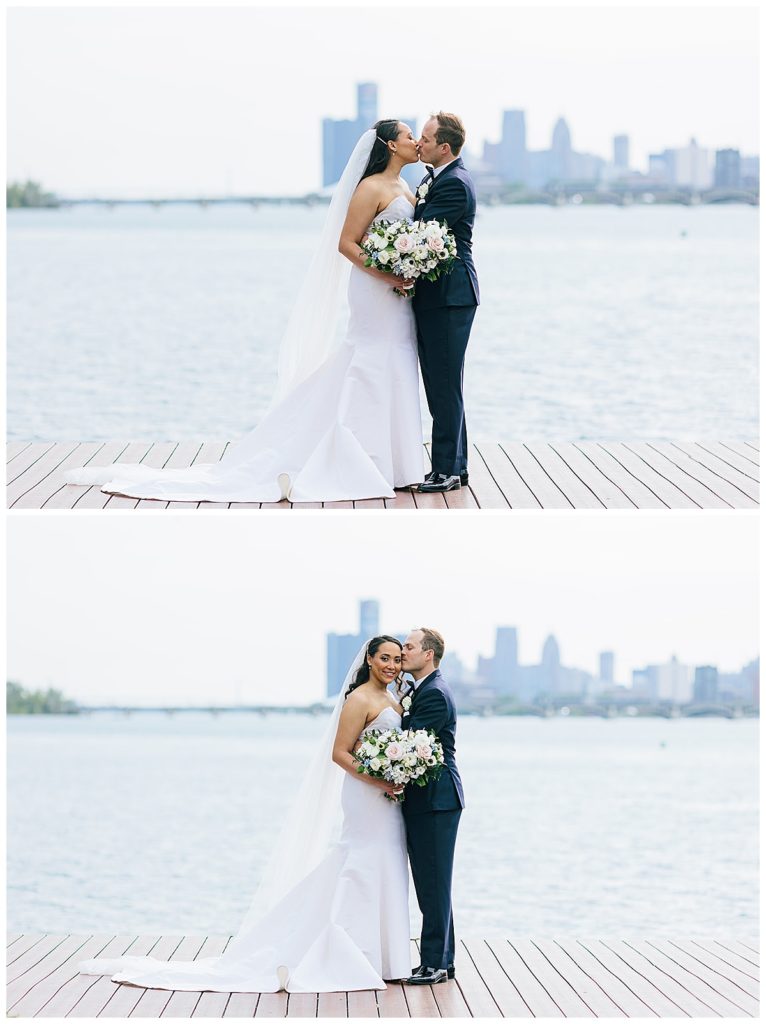 Bride and groom share a kiss and hug in front of Detroit skyline for elegant Yacht Club wedding.