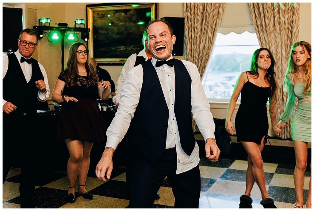 The groom is on the dance floor smiling with family and friends by Kayla Bouren photography.