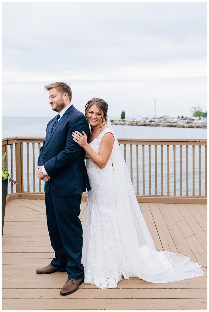 Bride hugging groom from behind for Lake St.Clair wedding