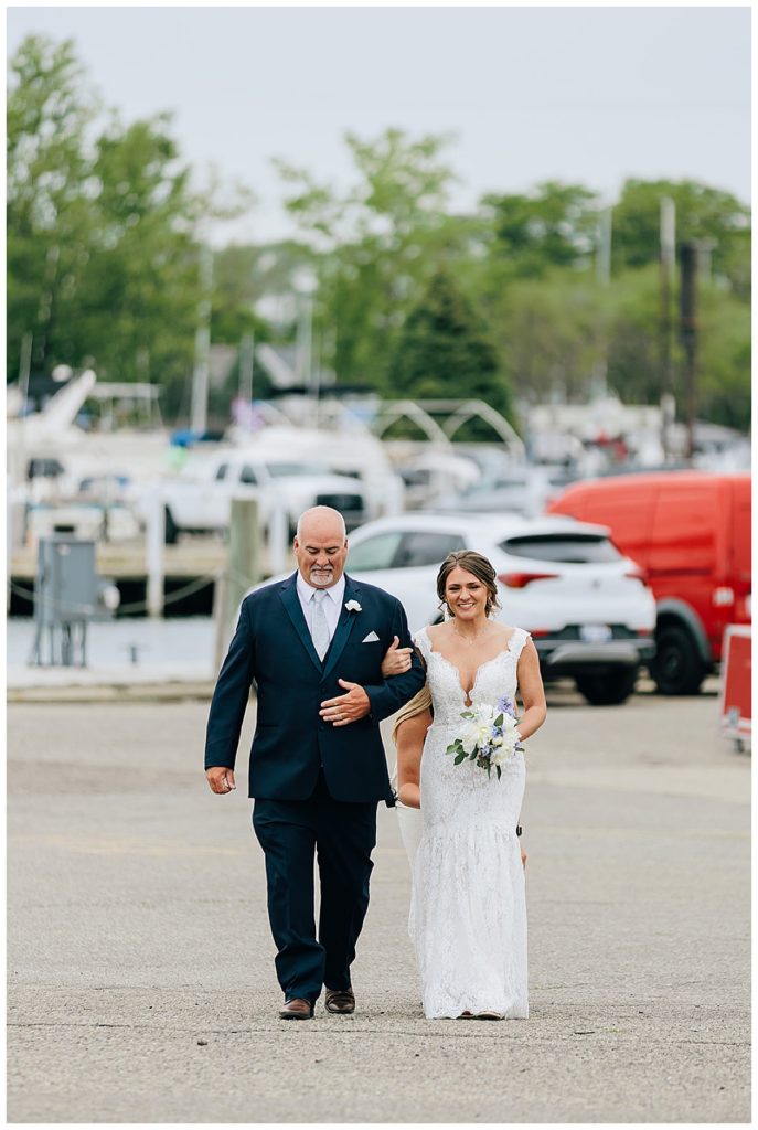 Bride walks down the aisle with father by Detroit wedding photographer
