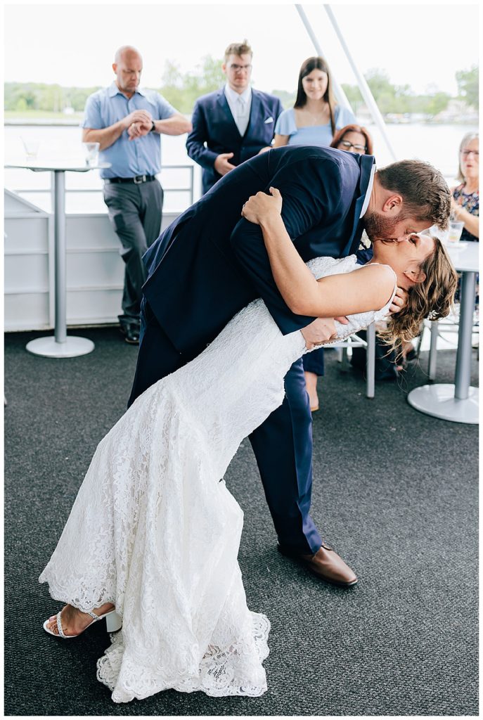 Groom dips bride for kiss during dance at Lake St.Clair wedding