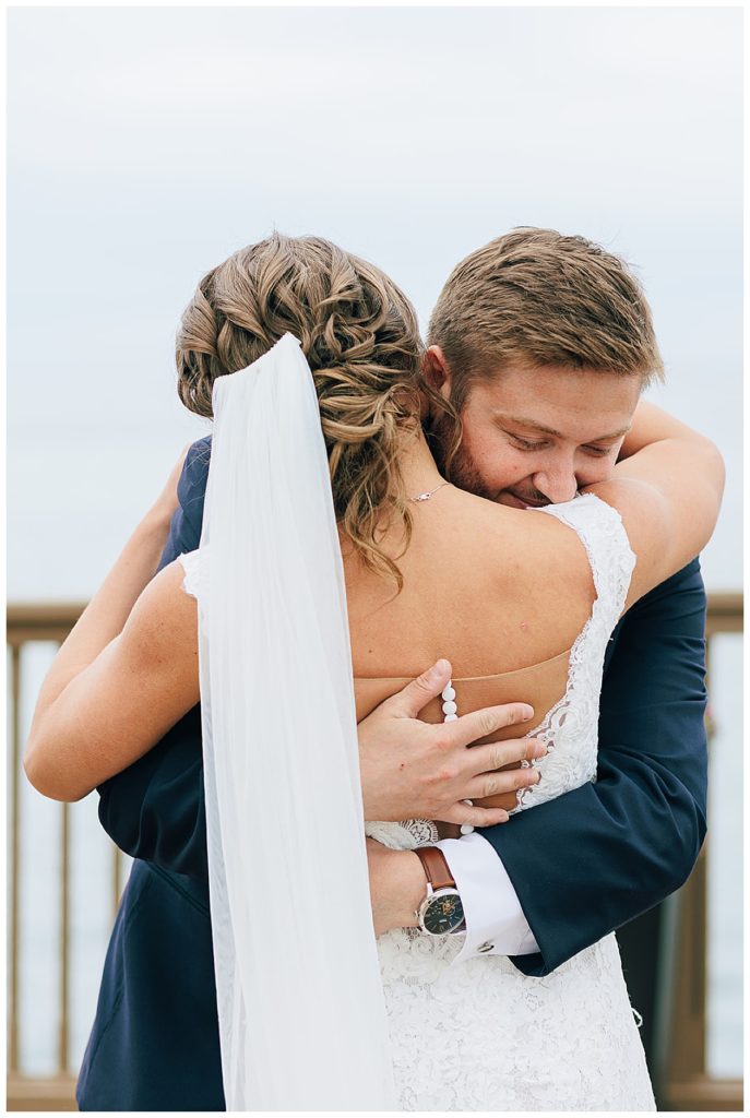 Bride and groom embrace in hug by Kayla Bouren Photography.