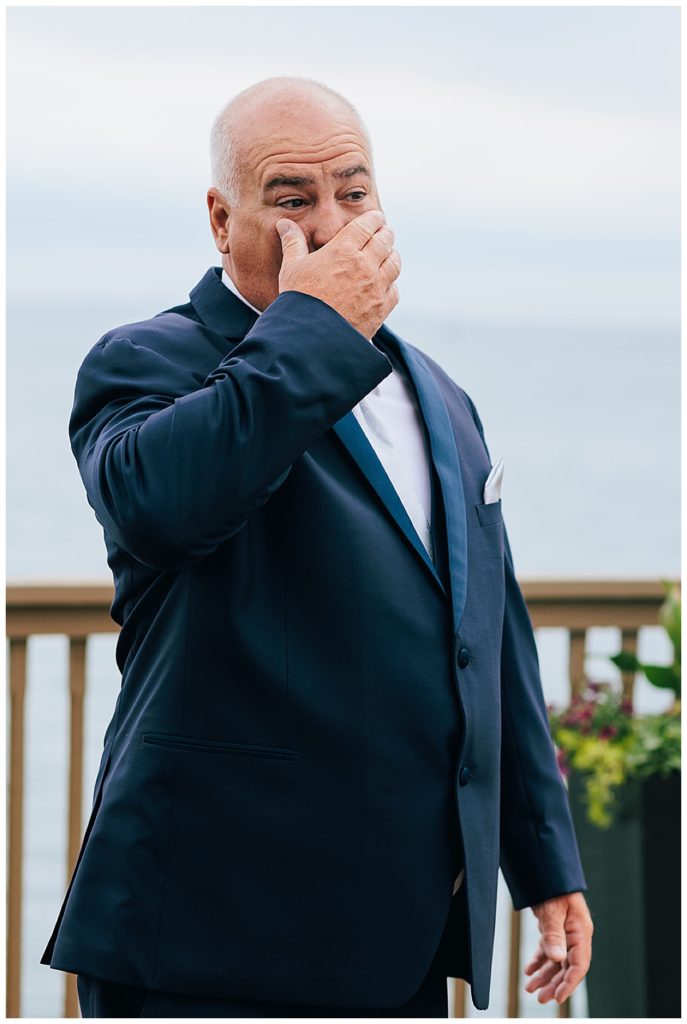 Father wipes tears from eyes by Detroit wedding photographer