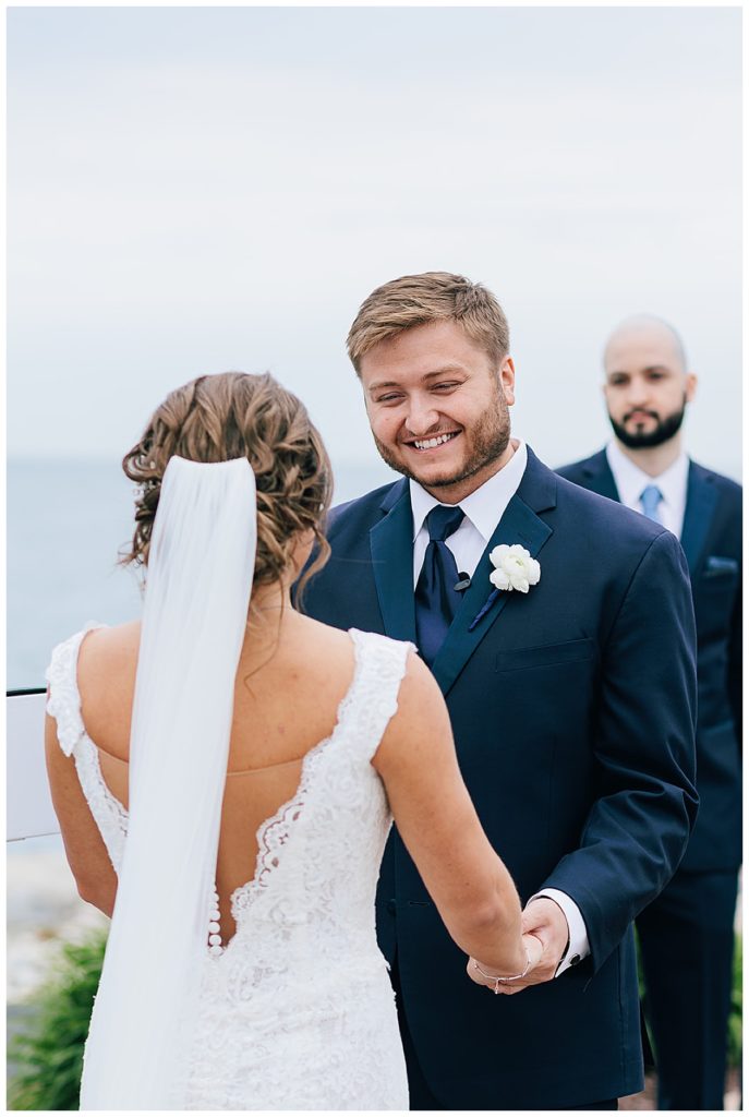 Groom smiles at bride by Kayla Bouren Photography.