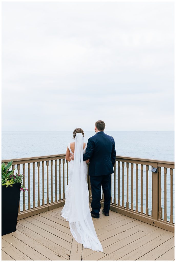 Bride and groom look at waterfront by Detroit wedding photographer