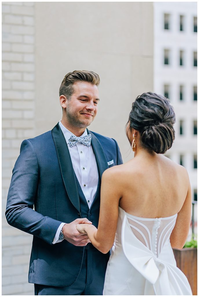 Groom smiles and holds brides hand for Kayla Bouren Photography