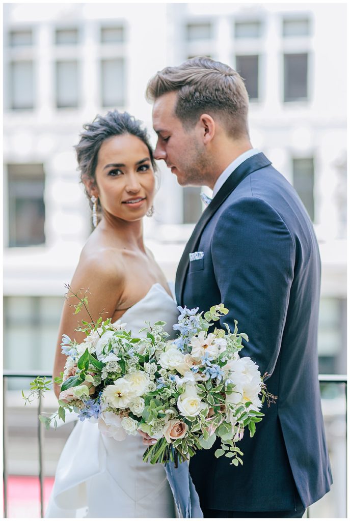 Floral bouquet in front of couple by Kayla Bouren Photography
