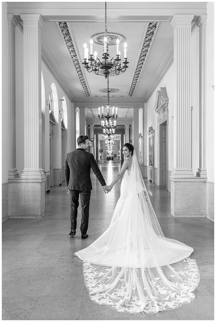 Husband and wife walk hand in hand by Kayla Bouren Photography