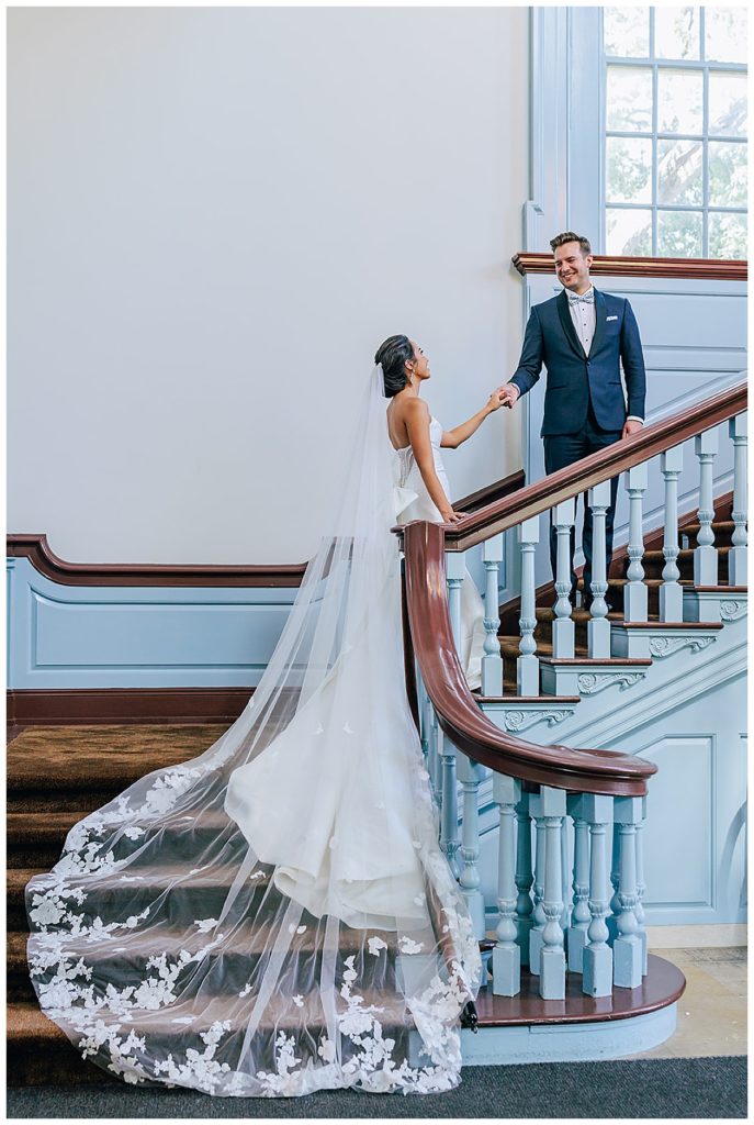 Husband leads wife up stairwell by Chic Detroit Wedding