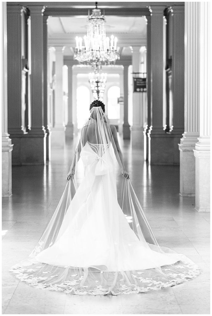 Bride hold wedding veil down hallway for Chic Detroit Wedding