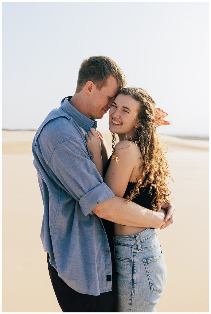 Couple holding each other close for Silver Lakes Sand Dunes Engagement Session.