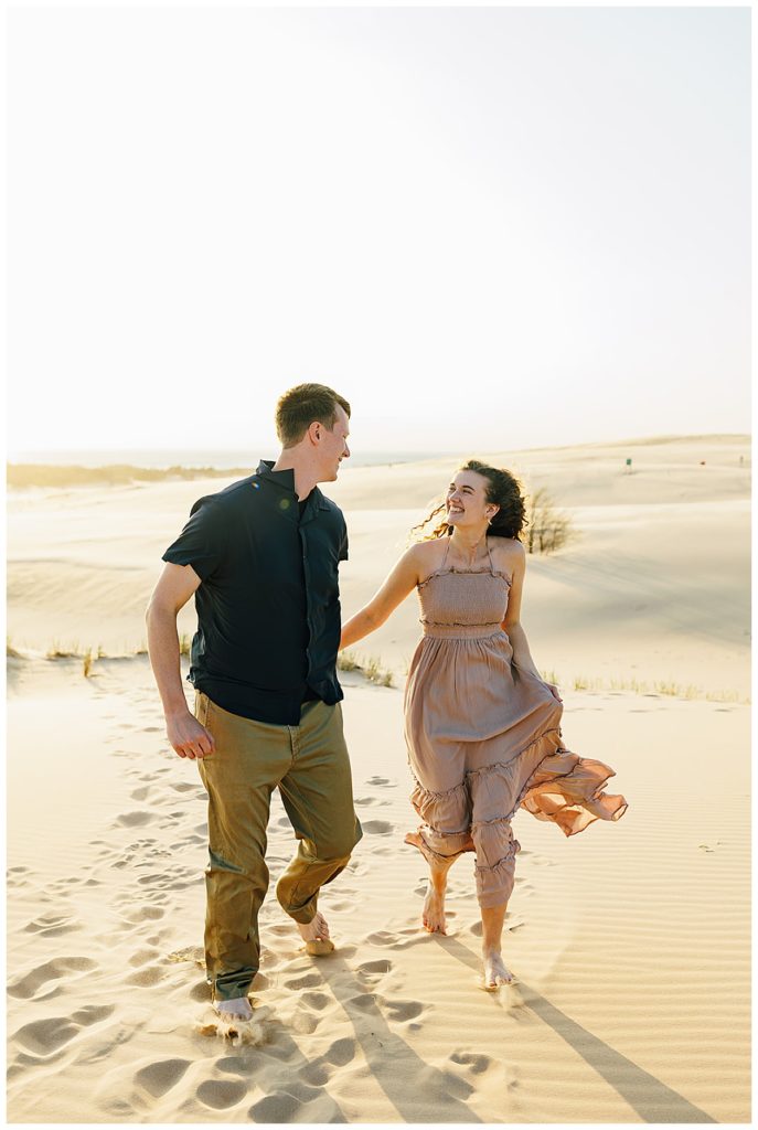 Couple runs through sand by Kayla Bouren Photography.
