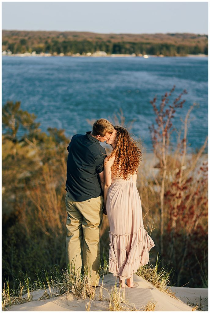 Couple kisses in front of water by Detroit Wedding Photographer
