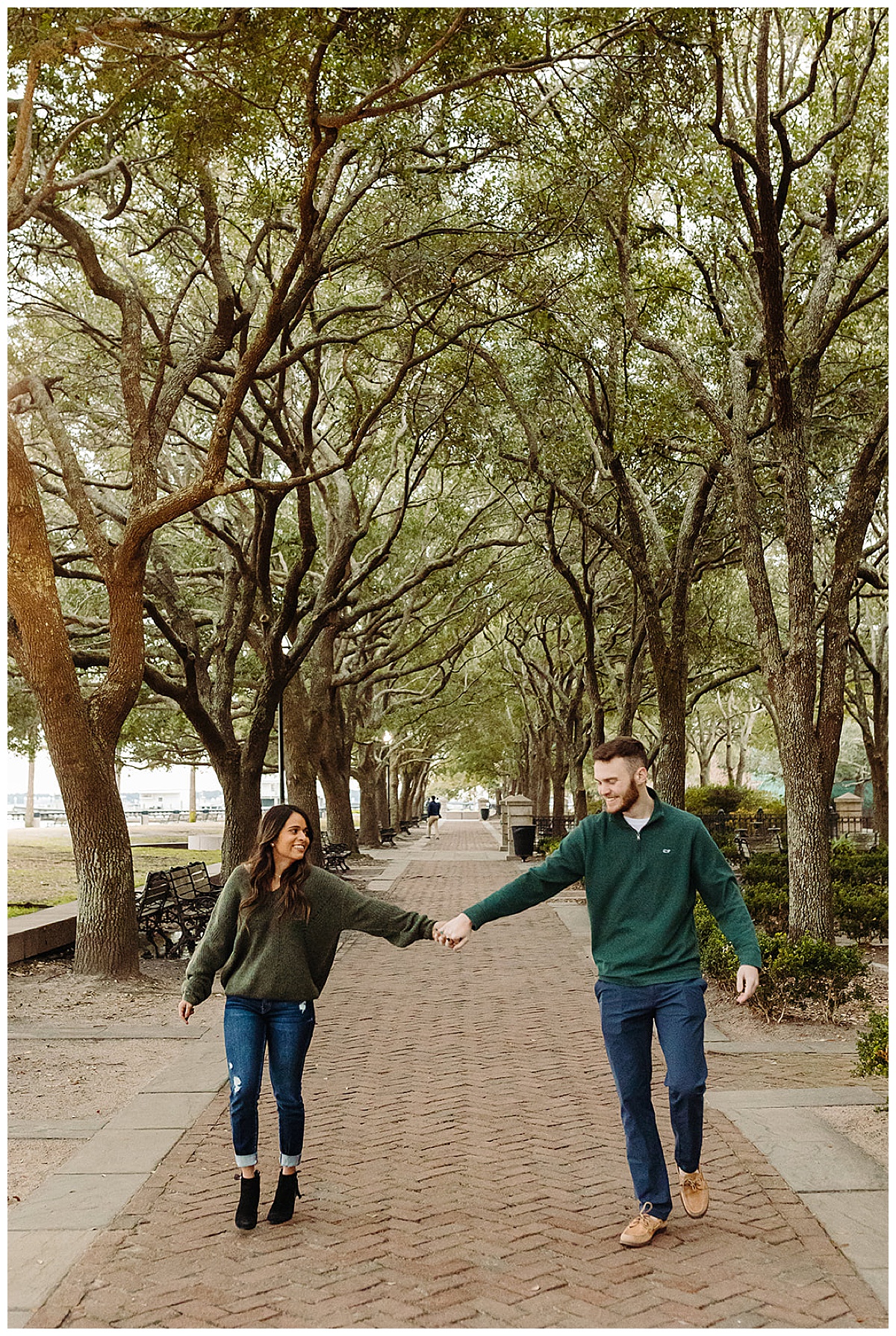 Couple holds hand walking under trees for Detroit Wedding Photographer