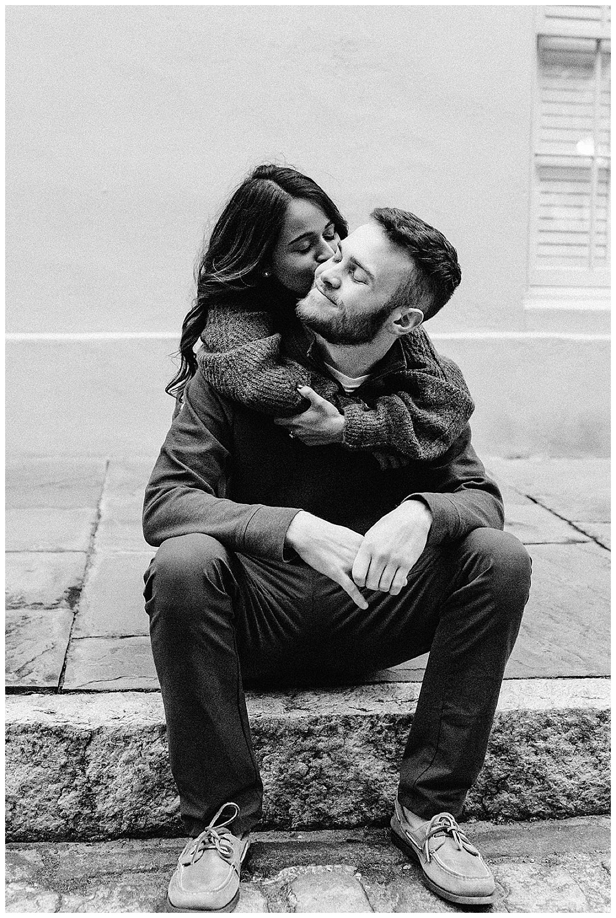 Woman kisses man sitting down for Detroit Wedding Photographer