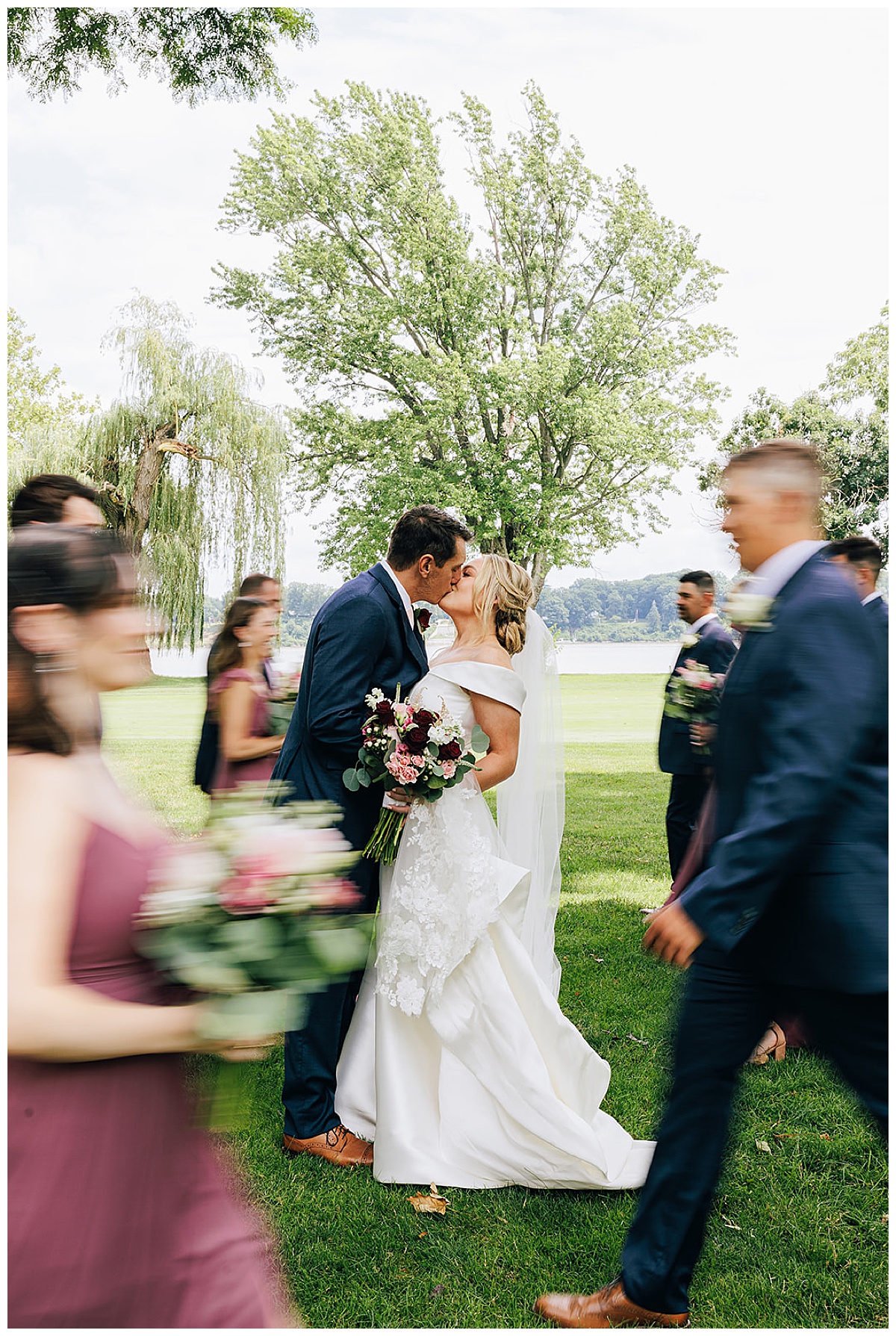 Wedding party walks near couple by Detroit Wedding Photographer