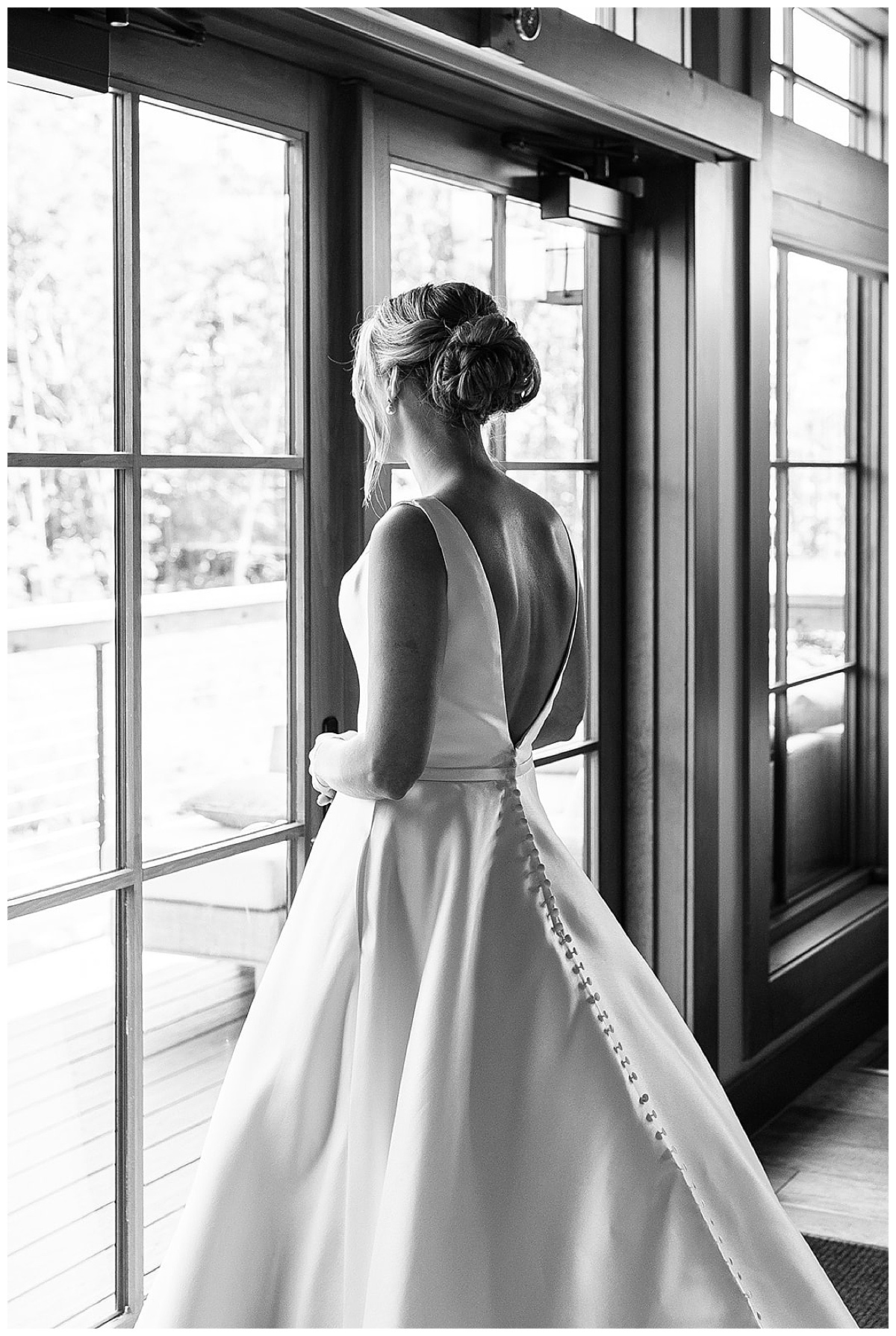 Bride looks out the window at Black River Barn South Haven