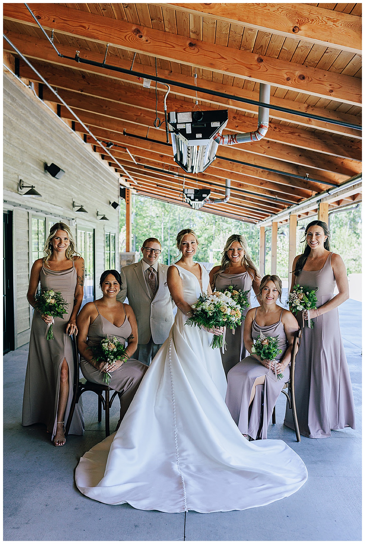 Bride stands in front of wedding party by Kayla Bouren Photography