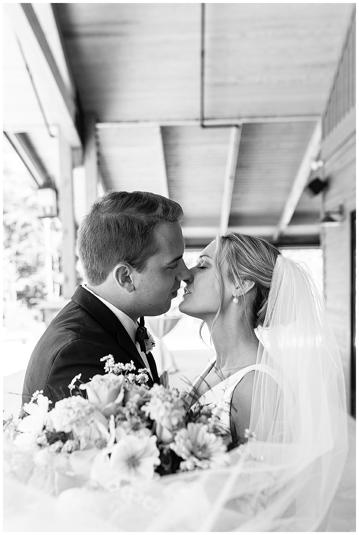 Groom kisses bride by Kayla Bouren Photography