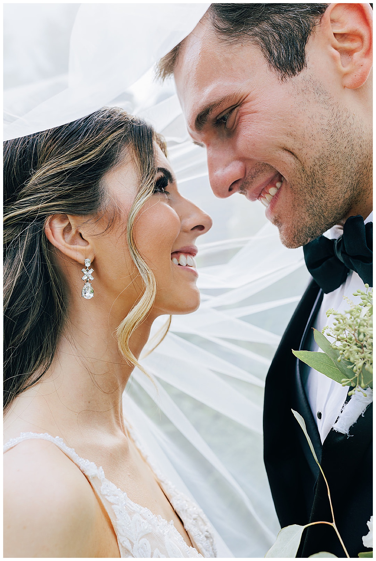 Bride and groom smile together under veil for Detroit Wedding Photographer