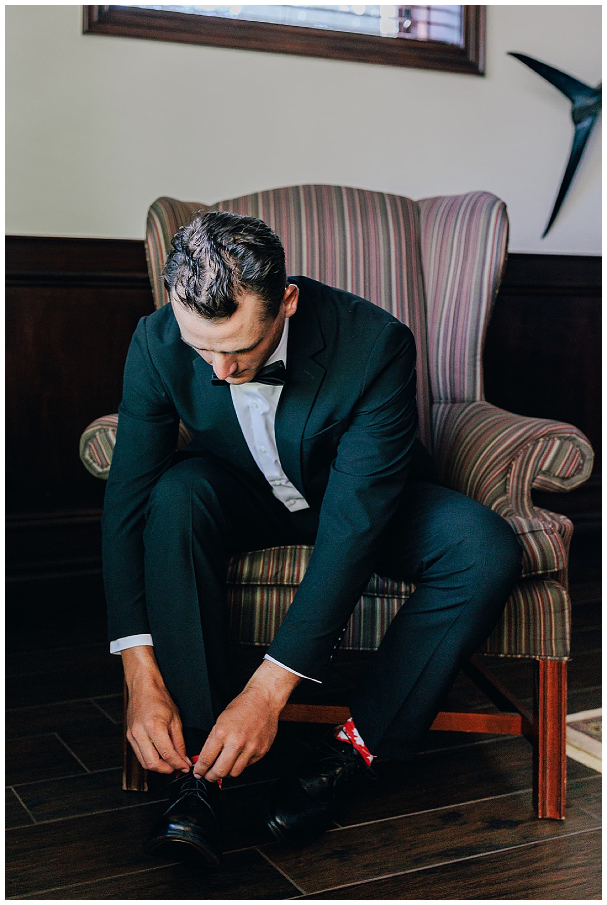 Grooms ties his shoes for Kayla Bouren Photography