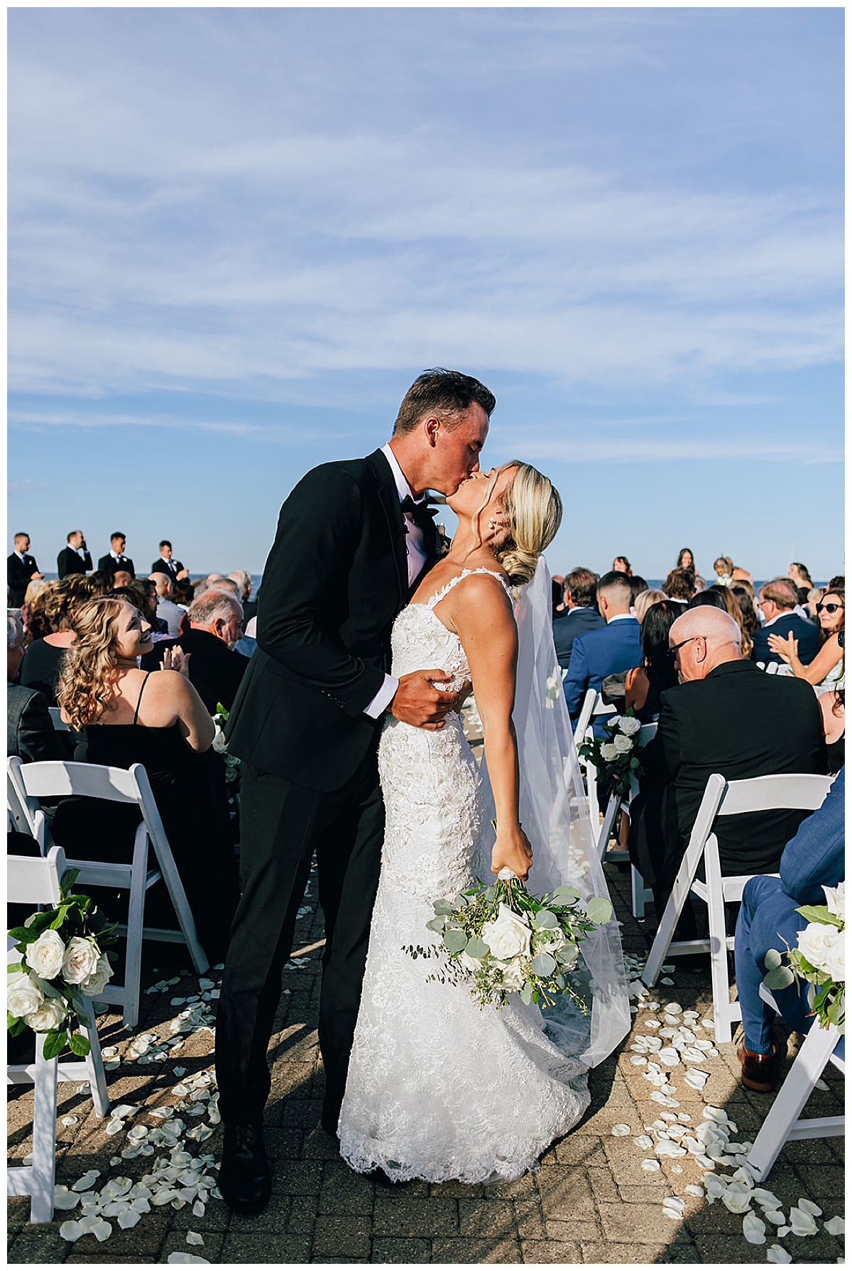 Husband and wife kiss down the aisle for Kayla Bouren Photography