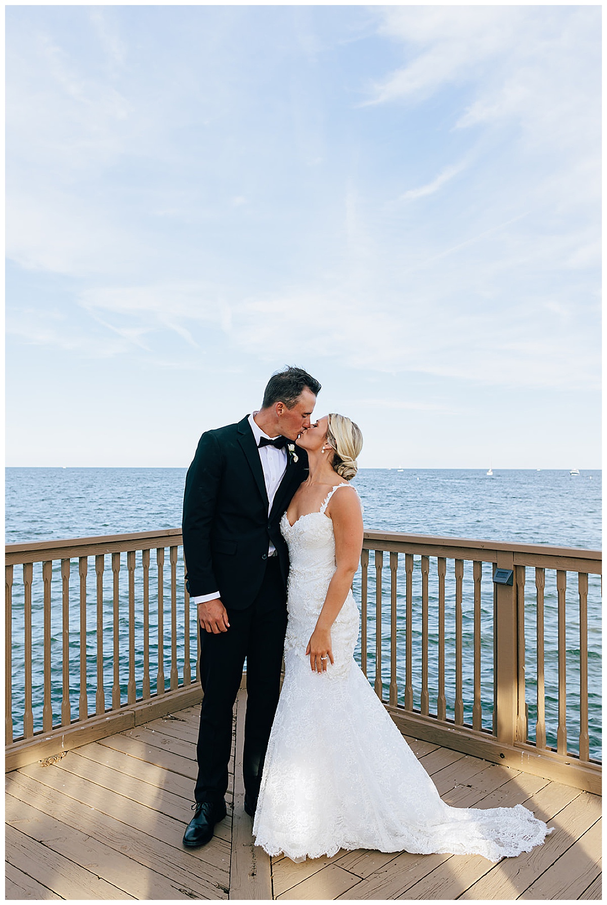 Bride and groom kiss on dock by Detroit Wedding Photographer